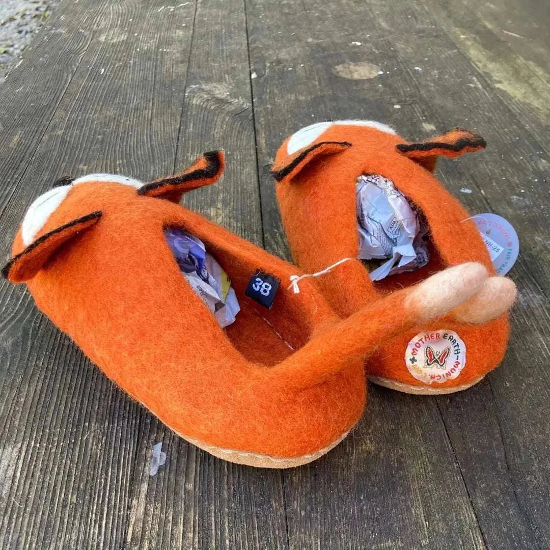 Fuchs - handgemachte Filzpantoffeln für Erwachsene in orange mit süßem Fuchsdesign auf Holztisch.