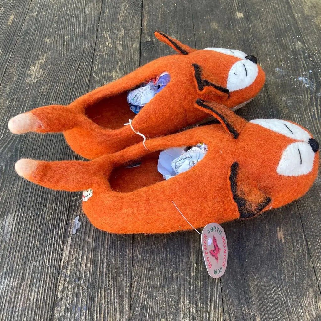 Fuchs - handgemachte Filzpantoffeln für Erwachsene in Orange mit Fuchsdesign auf Holzuntergrund