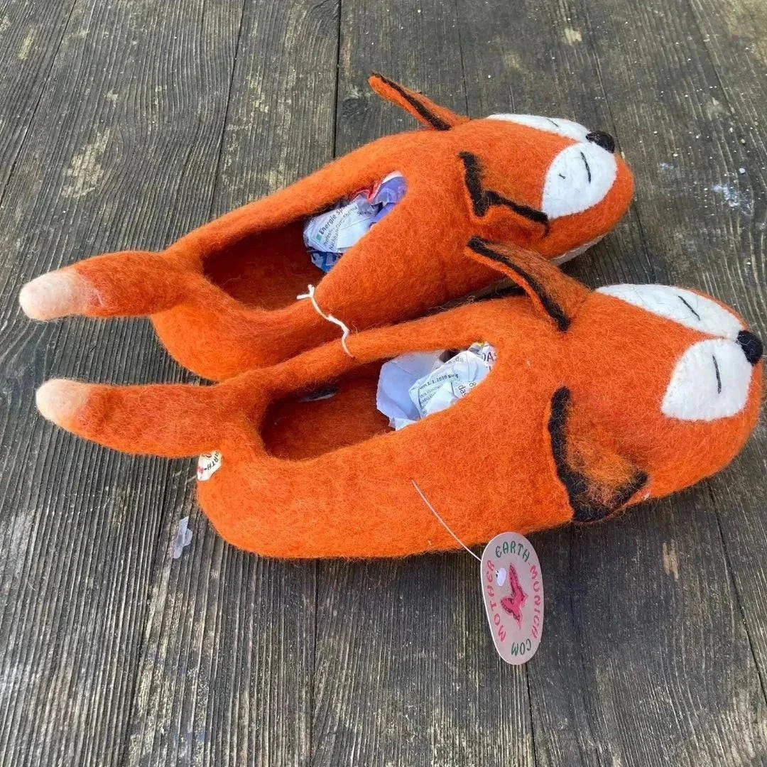 Fuchs - handgemachte Filzpantoffeln für Erwachsene in Orange mit Fuchsdesign auf Holzuntergrund