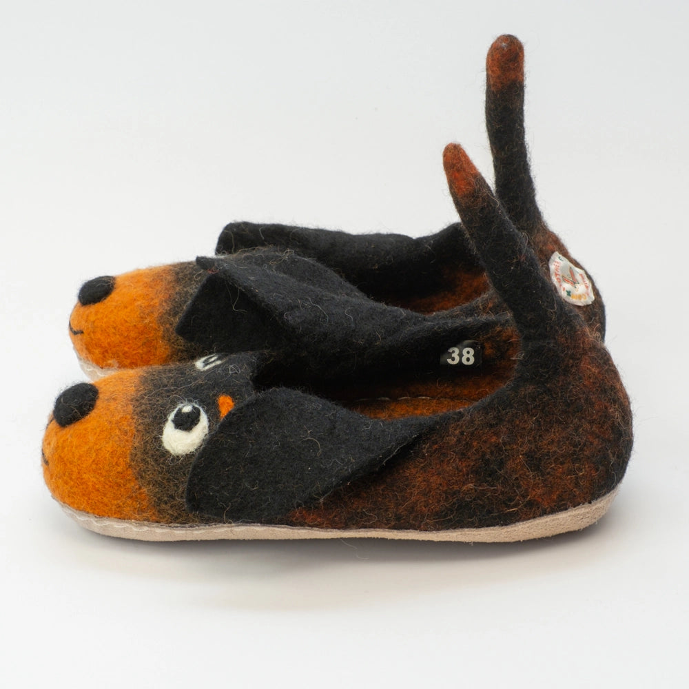 Hunde mit schwarzen Schlappohren Filzpantoffeln Halbschuhe Kinder, schwarz rotbraun, offene Augen, schwarzer Mund, rotbraune Augenbrauen, Gesicht freundlich, Kulleraugen, Kräftiger Schwanz zum Wackeln und als Einstegshilfe zu verwenden. Hochgezogene Wildledersohle, Marke MAUSSCHUH by MotherEarth-Munich. Ansicht: Von der Seite