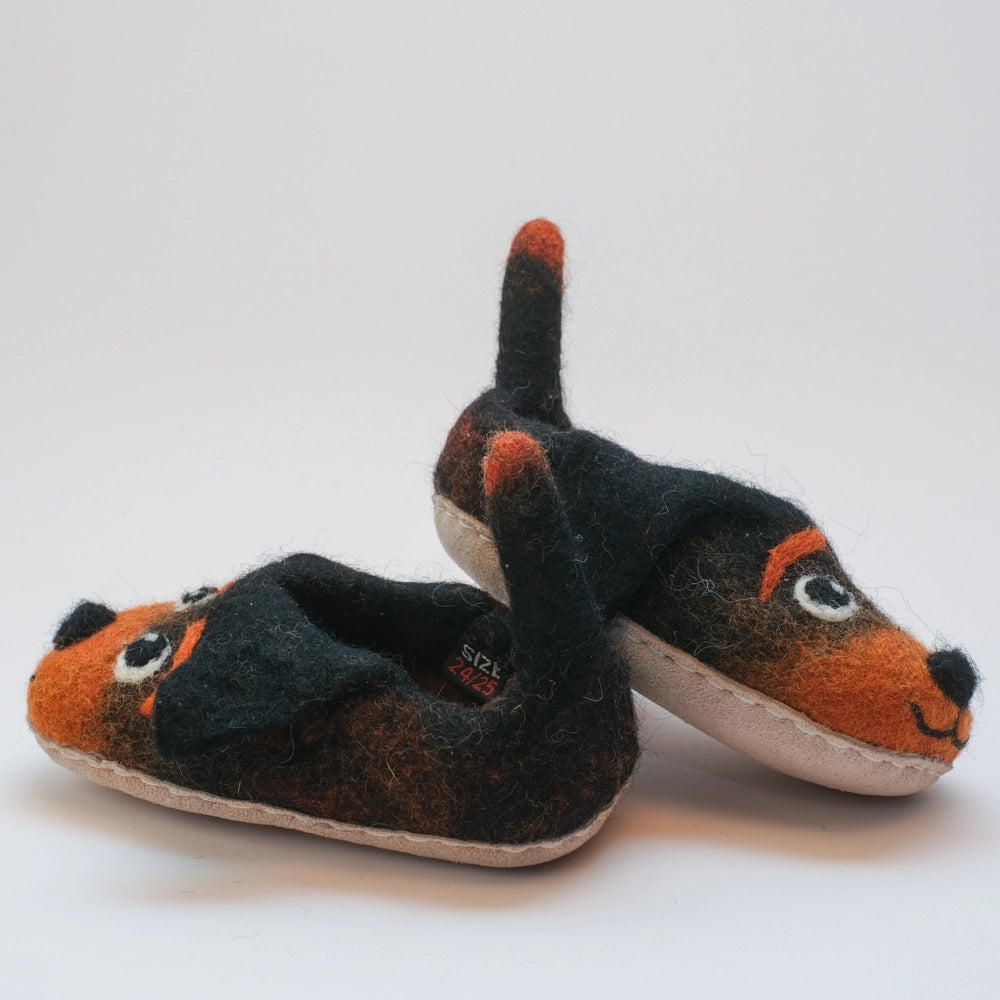 Hunde mit schwarzen Schlappohren Filzpantoffeln Halbschuhe Kinder, schwarz rotbraun, offene Augen, schwarzer Mund, rotbraune Augenbrauen, Gesicht freundlich, Kulleraugen, Kräftiger Schwanz zum Wackeln und als Einstegshilfe zu verwenden. Hochgezogene Wildledersohle, Marke MAUSSCHUH by MotherEarth-Munich. Ansicht: Von Seite