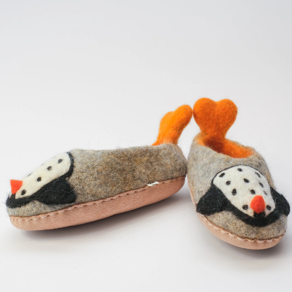 Pinguin Filzpantoffeln Halbschuh Kinder, mit herzförmigen Schwalbenschwanz Watscheln, gelb orange und außen grauer Untergrund, innen orange gelb, Körper des Pinguin Motivs weiß mit schwarzen Punkten, schwarze Flügel, orangener Schnabel. Der Pinguin schaut zum Kind. Hochgezogene rutschfeste Wildedersohle Marke: MAUSSCHUH by MotherEarth-Munich Ansicht: Von Vorne und der Seite