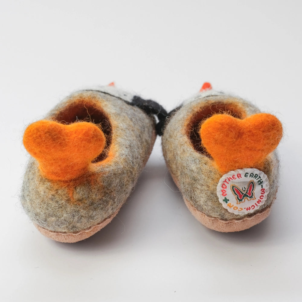 Pinguin Filzpantoffeln Halbschuh Kinder, mit herzförmigen Schwalbenschwanz Watscheln, gelb orange und außen grauer Untergrund, innen orange gelb, Körper des Pinguin Motivs weiß mit schwarzen Punkten, schwarze Flügel, orangener Schnabel. Der Pinguin schaut zum Kind. Hochgezogene Wildedersohle Marke: MAUSSCHUH by MotherEarth-Munich Ansicht: Von Hinten