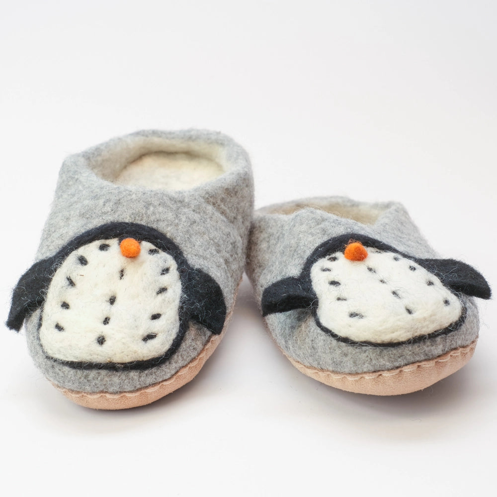 Pinguin Filzpantoffeln Halbschuh Erwachsene, silbergrauer Untergrund, innen naturweiß, Körper des Pinguin Motivs weiß mit schwarzen Punkten, schwarze Flügel, orangener Schnabel. Der Pinguin schaut nach außen zum Kind. Hochgezogene rutschfeste Wildedersohle Marke: MAUSSCHUH by MotherEarth-Munich Ansicht: Von Vorne 